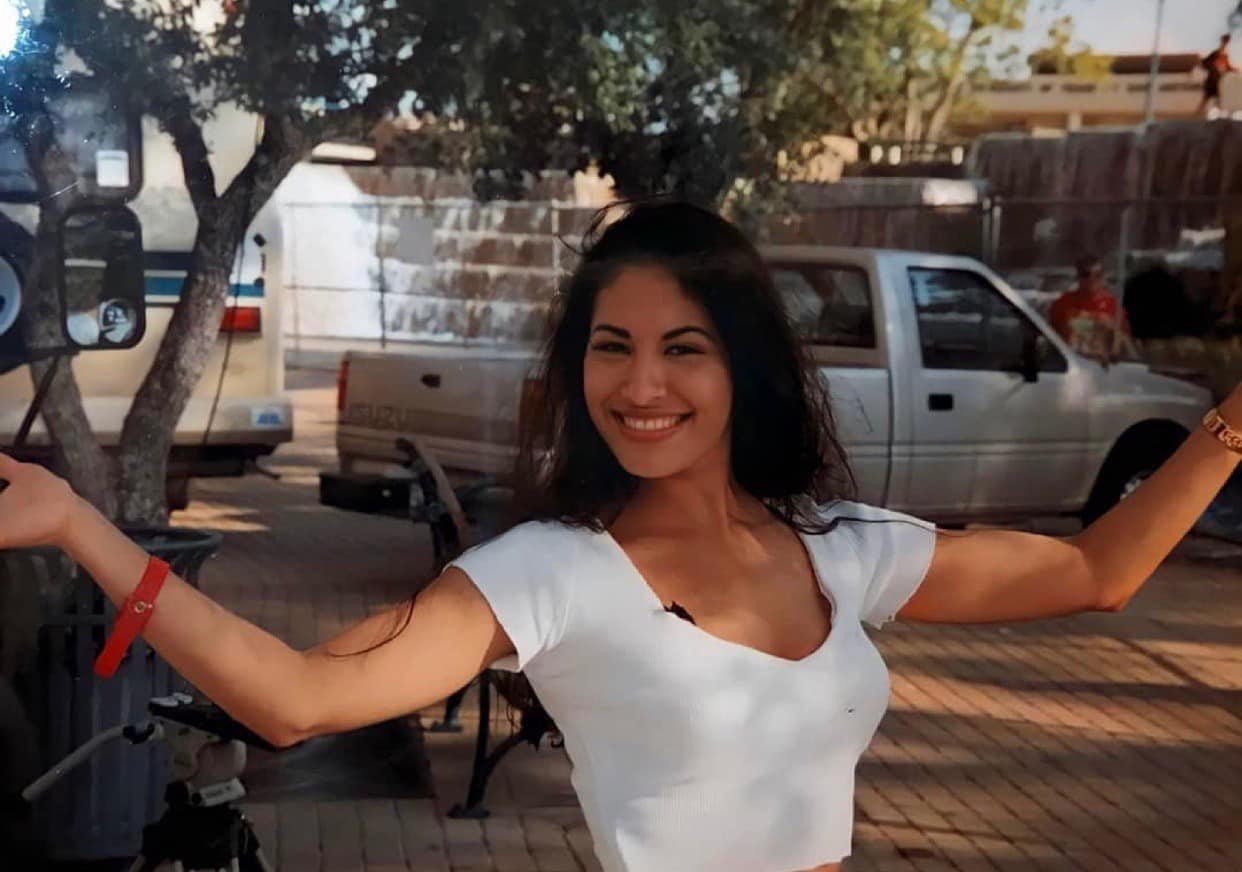 selena-quintanilla-texas-live-music-festival-1994 | Venclikovi.com Selena Quintanilla smiling outdoors at the Texas Live Music Festival in 1994, wearing a white crop top and her signature warm smile.