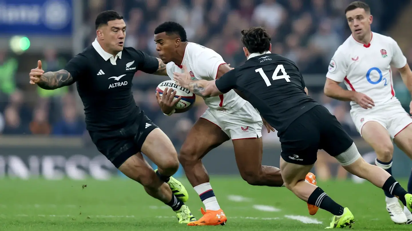 England vs New Zealand Rugby Tackle 2026jpg-2 | Venclikovi.com England rugby player breaks through two New Zealand defenders during a high-intensity match