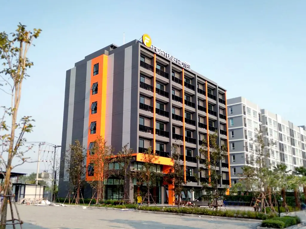 Fortune Hotel Buriram | Venclikovi.com The high-rise facade of the Fortune Hotel Buriram featuring modern grey and orange accents.