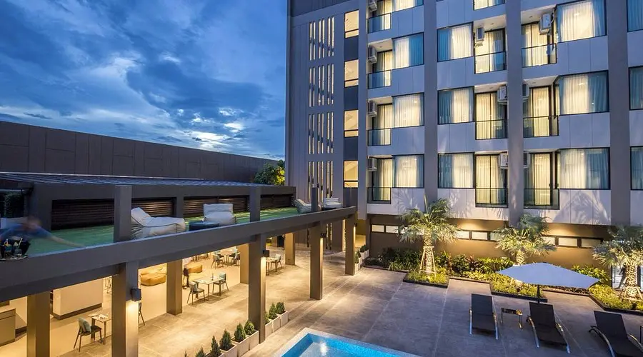 The Crystal Hotel Buriram | Venclikovi.com Night view of The Crystal Hotel Buriramās poolside lounge and modern multi-story building.